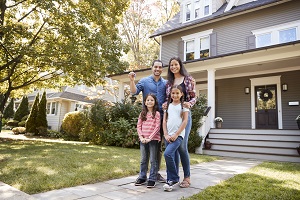 happy family standing outside of their new home